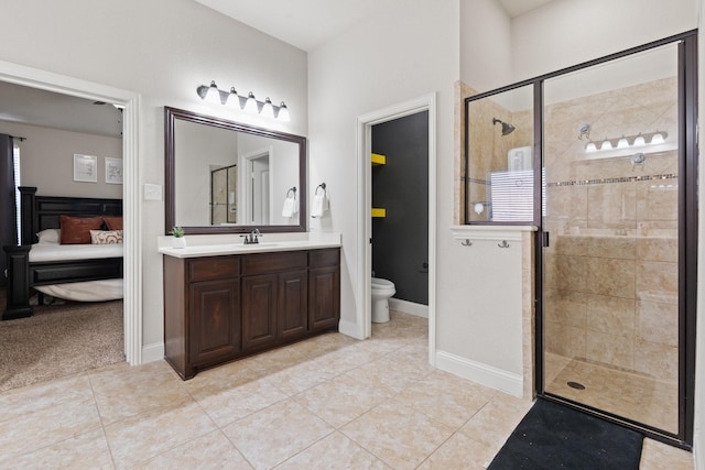 bathroom with a shower with door, vanity, tile patterned floors, and toilet