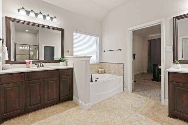 bathroom with tile patterned floors, lofted ceiling, independent shower and bath, and vanity