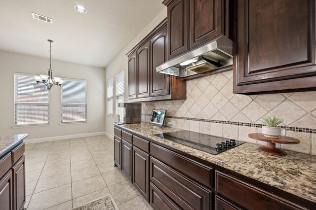 kitchen featuring baseboards, light stone countertops, black electric stovetop, under cabinet range hood, and light tile patterned flooring