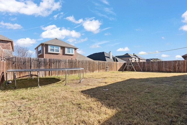 view of yard featuring a trampoline and a playground