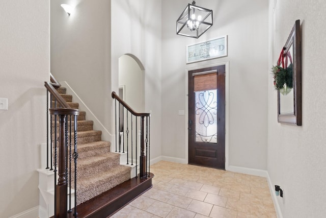 entrance foyer featuring light tile patterned floors and a towering ceiling