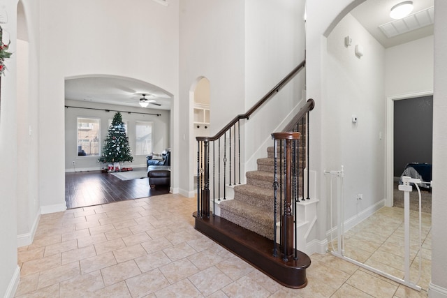 tiled entryway featuring a high ceiling and ceiling fan