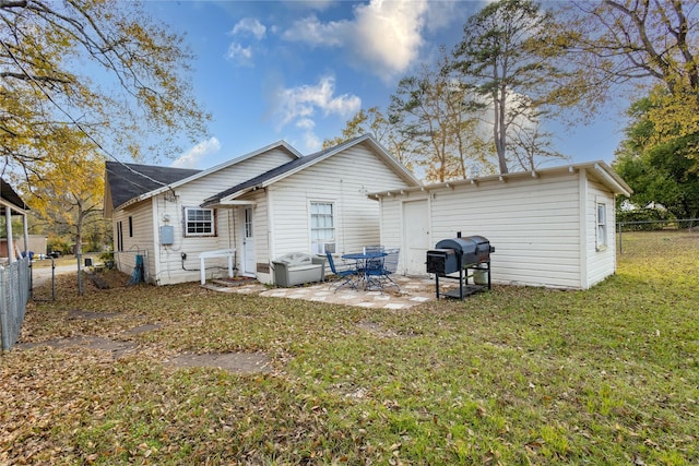 rear view of property with a lawn and a patio