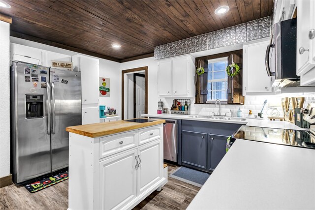 kitchen with butcher block countertops, dark hardwood / wood-style floors, white cabinetry, and appliances with stainless steel finishes