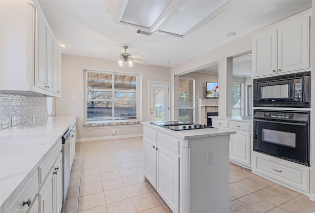 kitchen featuring a center island, tasteful backsplash, white cabinetry, and black appliances