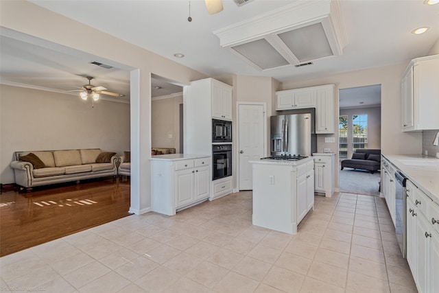 kitchen with ceiling fan, a kitchen island, light hardwood / wood-style flooring, white cabinets, and black appliances