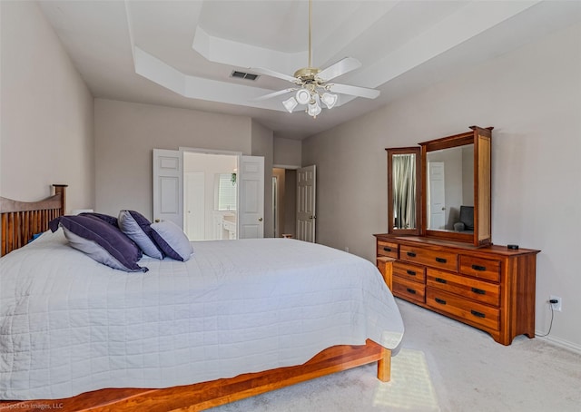 bedroom featuring light carpet, connected bathroom, and ceiling fan