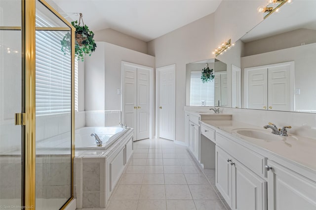 bathroom with vanity, lofted ceiling, a healthy amount of sunlight, and tile patterned flooring