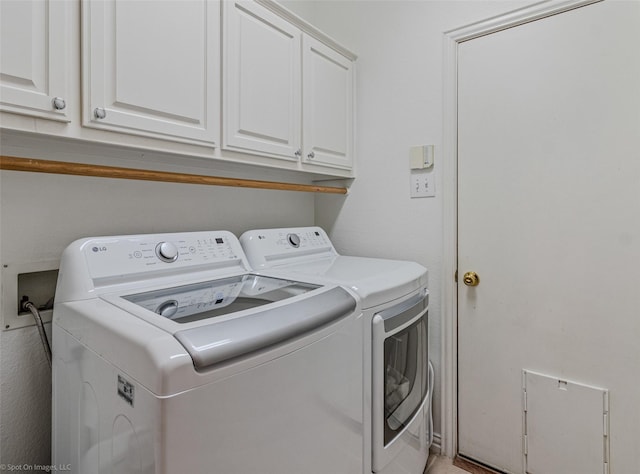 clothes washing area featuring cabinets and washing machine and clothes dryer