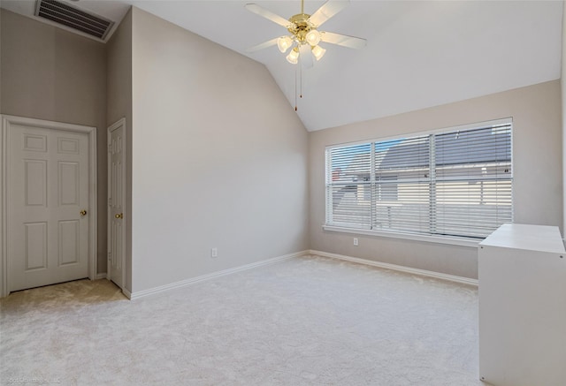 carpeted spare room featuring ceiling fan and high vaulted ceiling