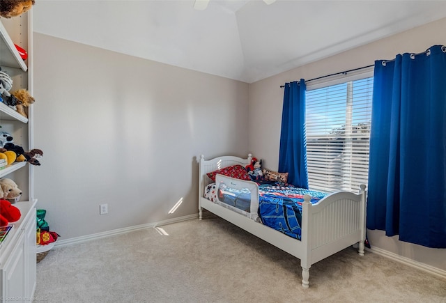 bedroom with ceiling fan, light colored carpet, and vaulted ceiling