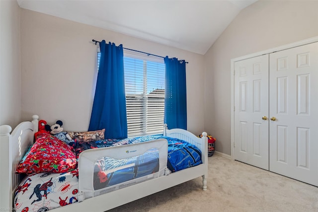 bedroom with a closet, carpet floors, and vaulted ceiling