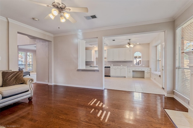 living room with light hardwood / wood-style flooring, a healthy amount of sunlight, and crown molding