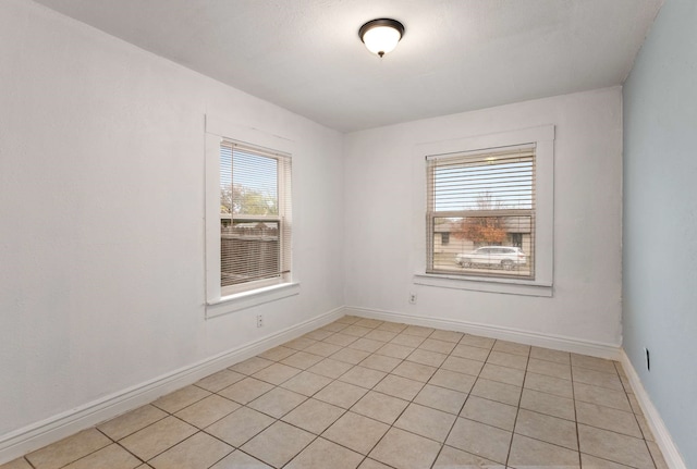 unfurnished room with light tile patterned floors and a wealth of natural light