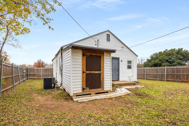 view of outdoor structure featuring central AC and a yard