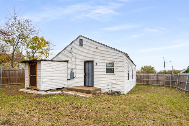 rear view of house featuring a lawn