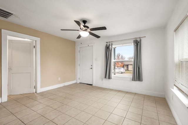 tiled empty room featuring ceiling fan