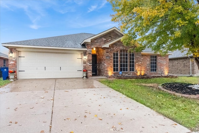 single story home with a front lawn, concrete driveway, brick siding, and an attached garage