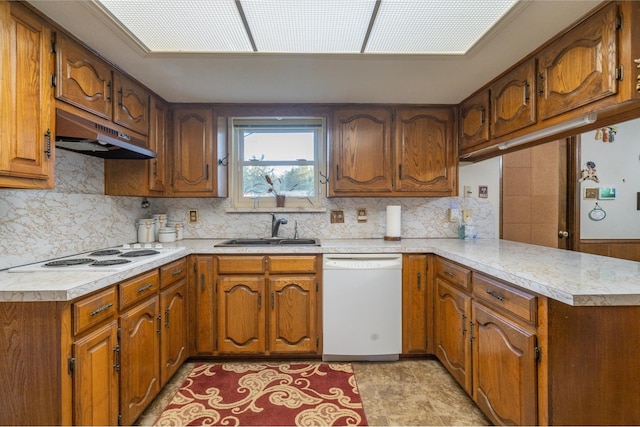 kitchen featuring backsplash, kitchen peninsula, sink, and white appliances