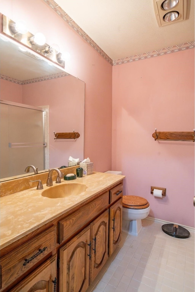 bathroom with tile patterned flooring, vanity, toilet, and an enclosed shower