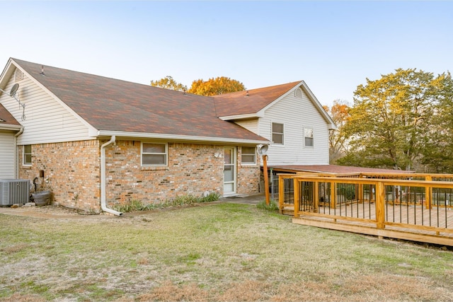 rear view of house with a lawn, central air condition unit, and a deck