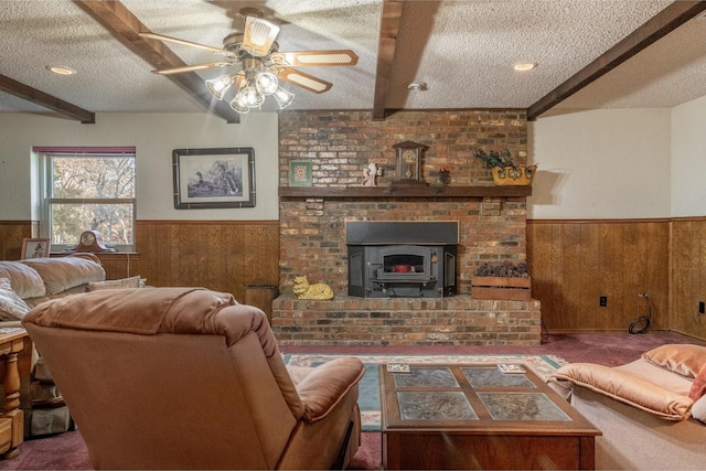 living room featuring a textured ceiling, ceiling fan, wooden walls, dark colored carpet, and beamed ceiling