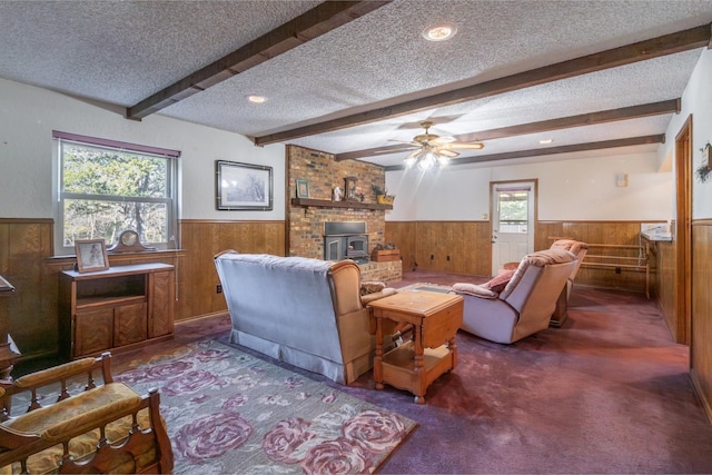 living room featuring beamed ceiling, a wood stove, and a textured ceiling