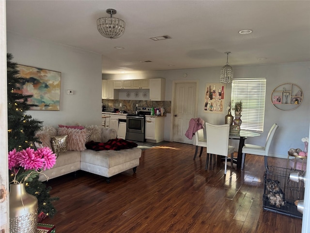 living room with sink, dark hardwood / wood-style floors, and an inviting chandelier