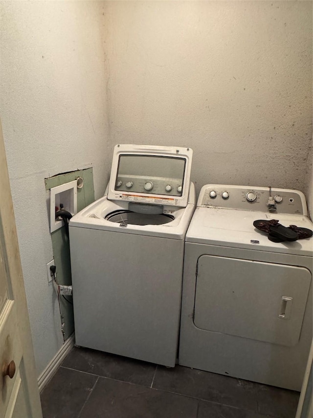 laundry room featuring washer and dryer and dark tile patterned flooring