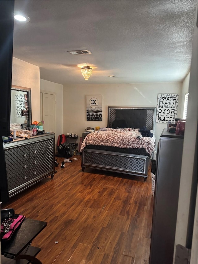 bedroom featuring a textured ceiling and dark wood-type flooring