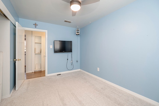 unfurnished bedroom featuring light colored carpet, a closet, and ceiling fan