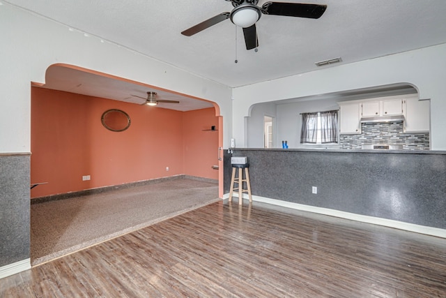 unfurnished living room featuring hardwood / wood-style flooring and ceiling fan