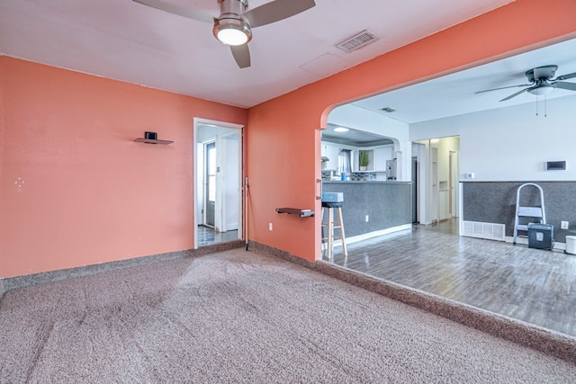 unfurnished living room with ceiling fan and carpet