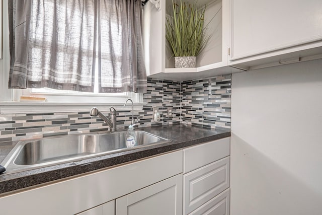 kitchen with backsplash, sink, and white cabinets