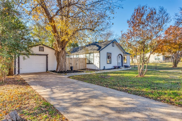 view of front of house featuring a garage, an outdoor structure, and a front lawn