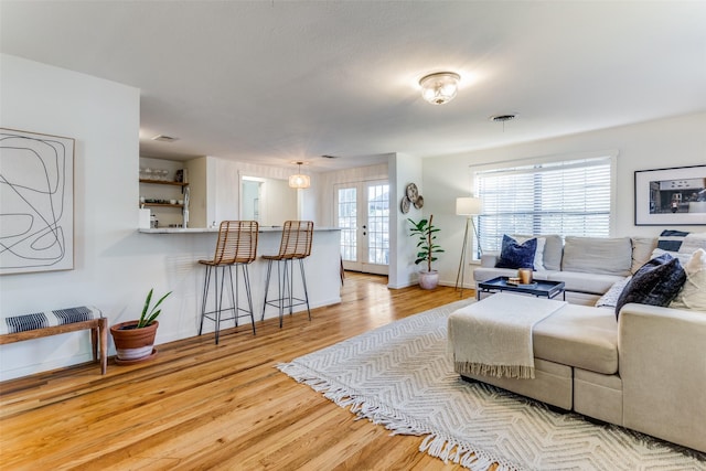 living room featuring french doors and light hardwood / wood-style flooring