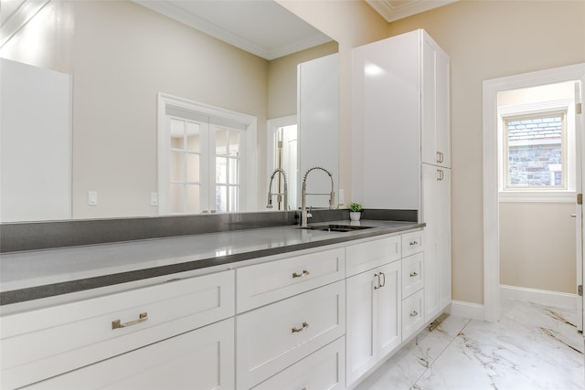 kitchen with white cabinetry, sink, and ornamental molding