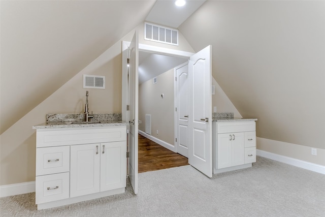 bathroom with hardwood / wood-style floors, vanity, vaulted ceiling, and toilet