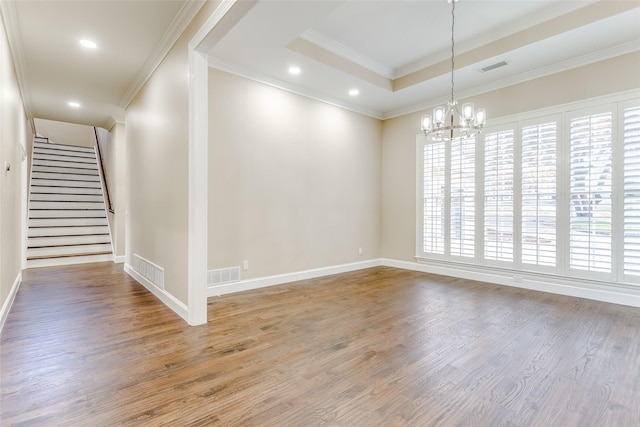 unfurnished room with wood-type flooring, ornamental molding, and a chandelier