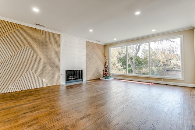 unfurnished living room featuring a fireplace, hardwood / wood-style floors, and ornamental molding