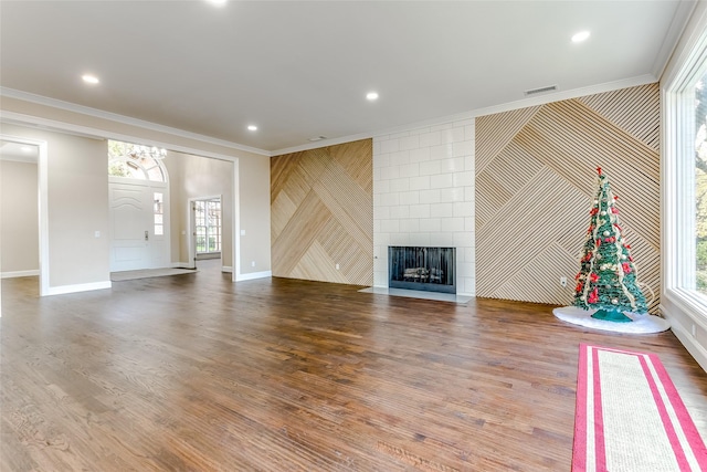 unfurnished living room featuring plenty of natural light, ornamental molding, and hardwood / wood-style flooring