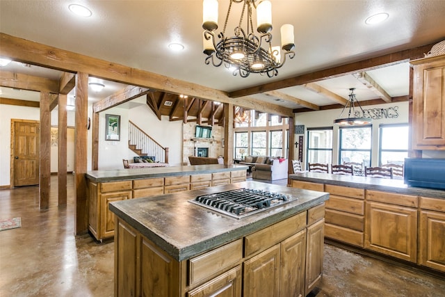 kitchen featuring plenty of natural light, a center island, hanging light fixtures, and stainless steel gas cooktop