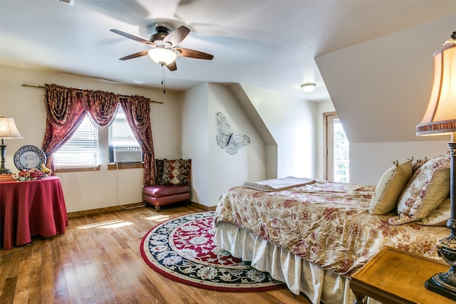 bedroom featuring ceiling fan, cooling unit, and wood-type flooring