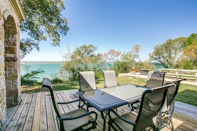 deck with a water view and a fire pit