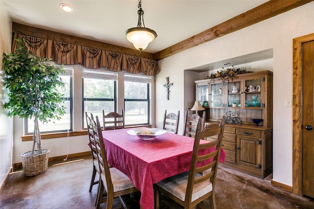 dining space featuring beam ceiling and plenty of natural light