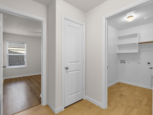 clothes washing area with hookup for a gas dryer, light hardwood / wood-style flooring, washer hookup, and hookup for an electric dryer