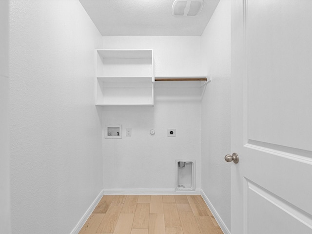 clothes washing area with hookup for an electric dryer, hookup for a washing machine, hardwood / wood-style flooring, and gas dryer hookup