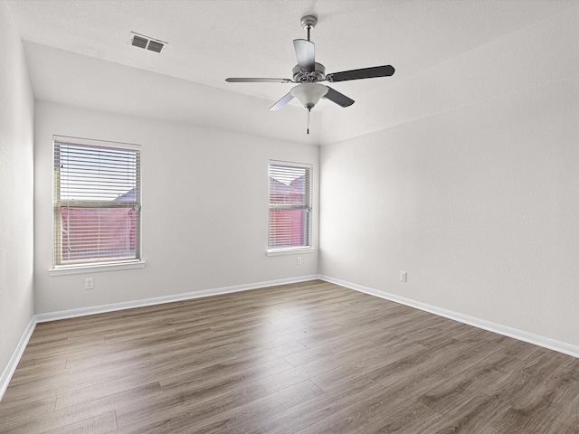 empty room featuring dark hardwood / wood-style flooring and ceiling fan