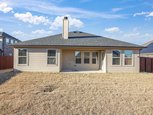 rear view of property featuring a lawn and a patio area