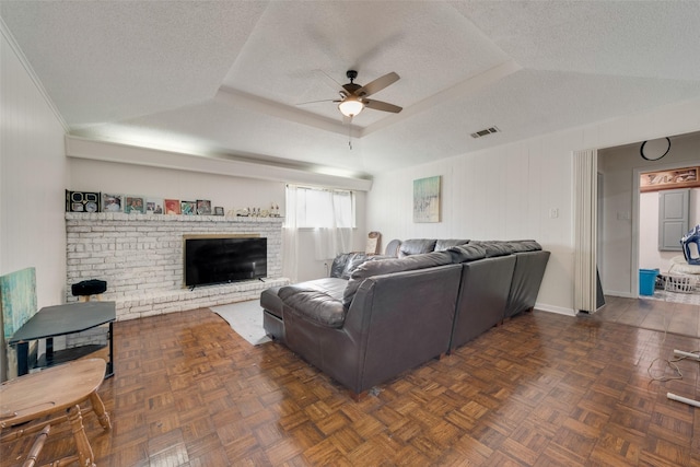 living room with ceiling fan, dark parquet flooring, and a textured ceiling